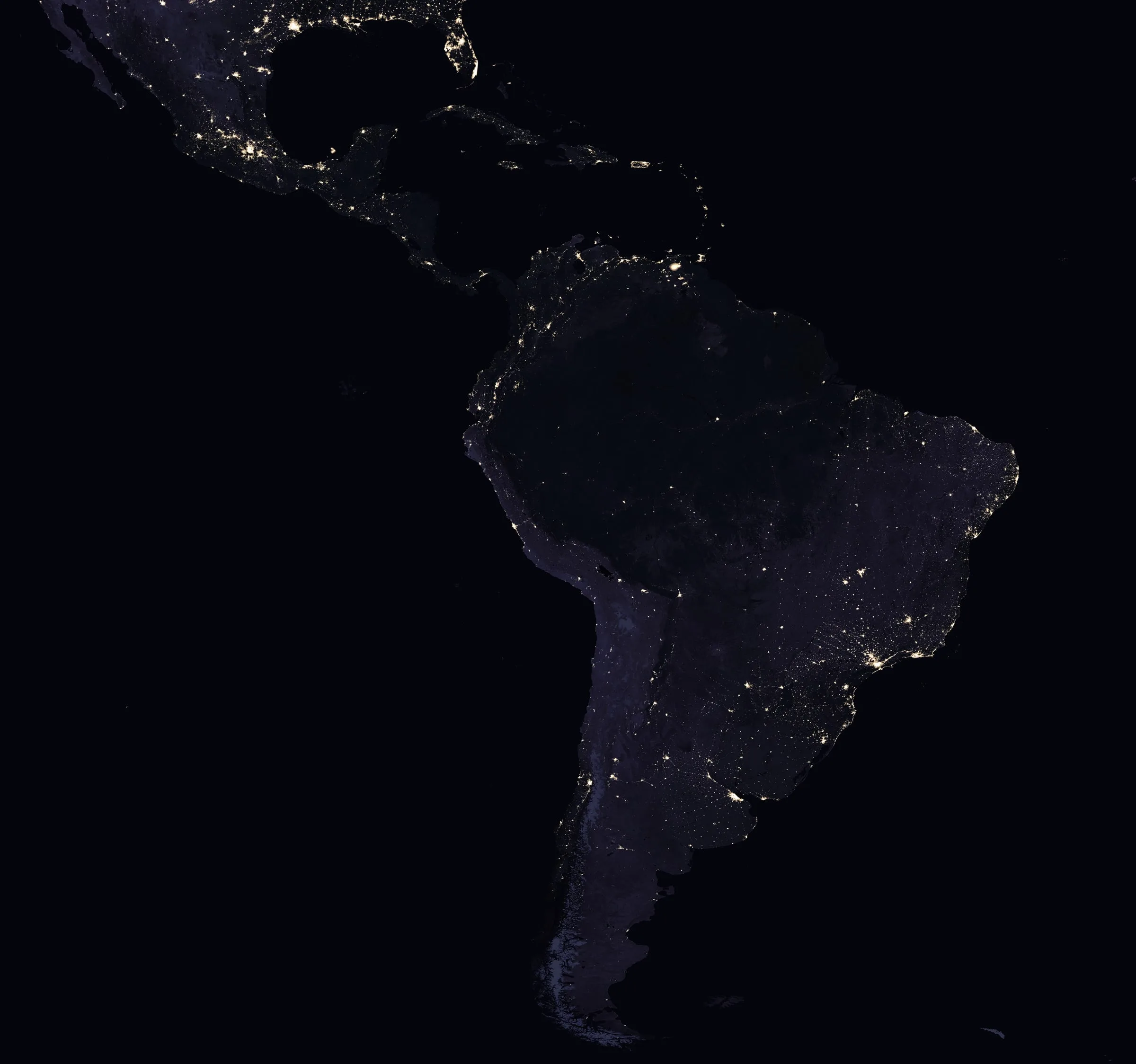 Latinoamérica de noche vista desde el espacio: las luces de sus ciudades sobre el continente oscuro.